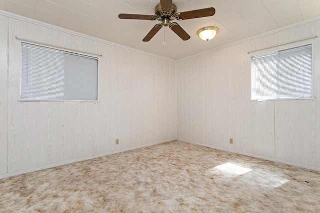 carpeted empty room with crown molding and a ceiling fan