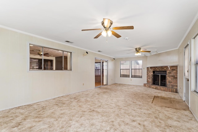 unfurnished living room with ornamental molding, ceiling fan, carpet floors, and a brick fireplace