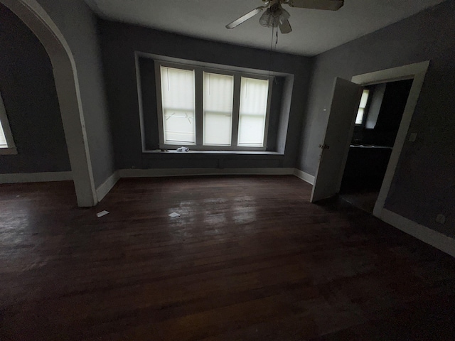 2726 13th St, Port Arthur, TX 77640 - spare room featuring arched walkways, ceiling fan, and dark wood-style flooring