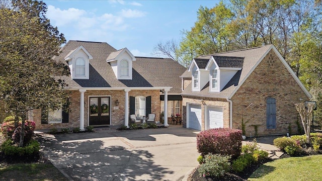2175 Brewton Cir, Beaumont, TX 77706 - view of front of home featuring brick siding, concrete driveway, french doors, and a shingled roof