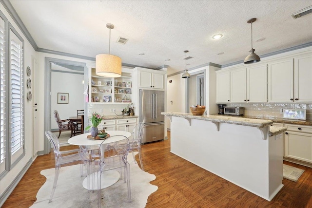 2175 Brewton Cir, Beaumont, TX 77706 - kitchen featuring high end refrigerator, open shelves, a kitchen breakfast bar, decorative backsplash, and ornamental molding