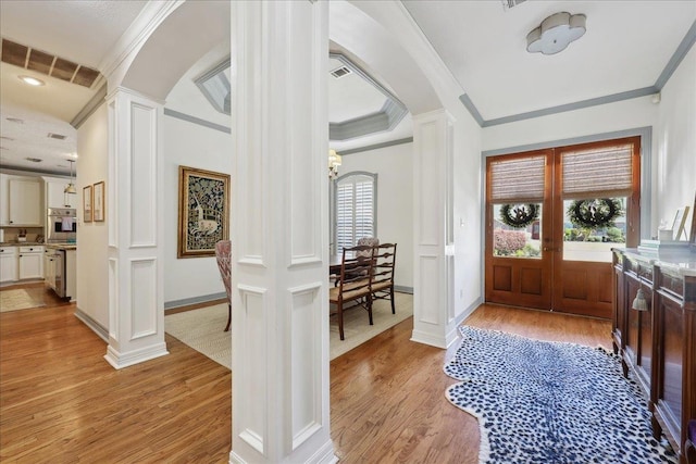 2175 Brewton Cir, Beaumont, TX 77706 - foyer featuring decorative columns, light wood finished floors, arched walkways, ornamental molding, and a chandelier