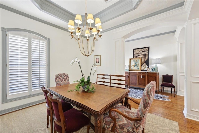 2175 Brewton Cir, Beaumont, TX 77706 - dining area featuring a chandelier, crown molding, ornate columns, arched walkways, and light wood-type flooring