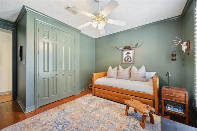 2175 Brewton Cir, Beaumont, TX 77706 - bedroom featuring crown molding, wood finished floors, a closet, baseboards, and ceiling fan