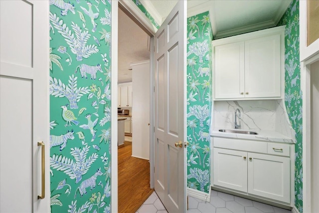 2175 Brewton Cir, Beaumont, TX 77706 - bathroom featuring a sink, wallpapered walls, crown molding, and wood finished floors