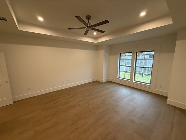 3547 Lily Ln, Beaumont, TX 77713 - spare room with a tray ceiling, baseboards, ceiling fan, dark wood-style flooring, and recessed lighting