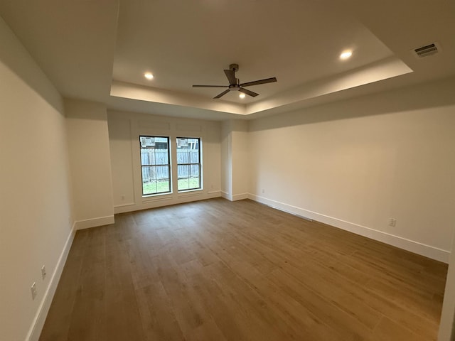 3547 Lily Ln, Beaumont, TX 77713 - spare room featuring a tray ceiling, baseboards, dark wood-type flooring, a ceiling fan, and recessed lighting