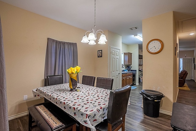 dining area with dark wood-style floors, baseboards, attic access, and a chandelier