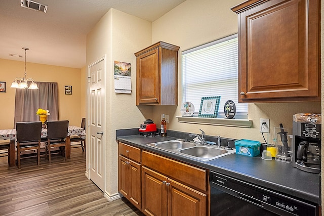 kitchen featuring dishwasher, a sink, dark countertops, wood finished floors, and brown cabinetry