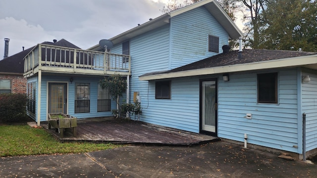 rear view of house with a balcony and a wooden deck