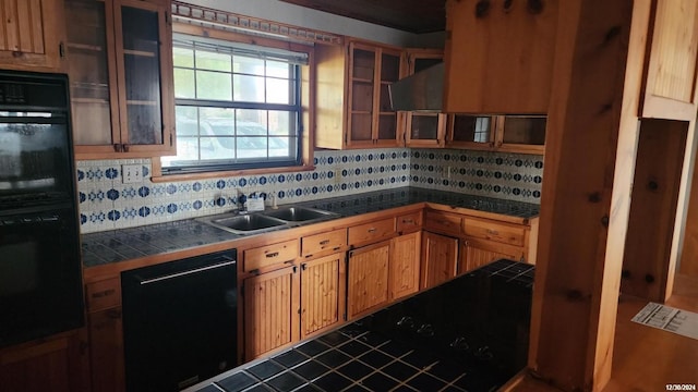 kitchen featuring decorative backsplash, sink, black appliances, and range hood