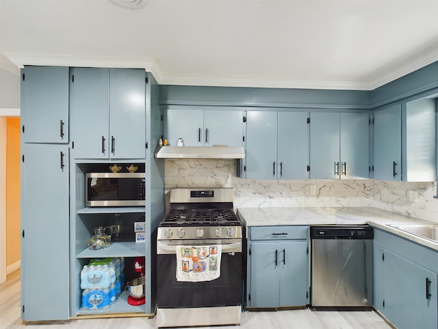 kitchen with blue cabinets, tasteful backsplash, and appliances with stainless steel finishes