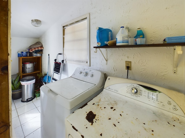 clothes washing area featuring washer and dryer and light tile patterned floors