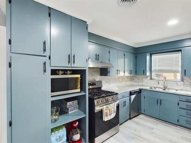 kitchen with blue cabinets, sink, tasteful backsplash, appliances with stainless steel finishes, and light stone countertops