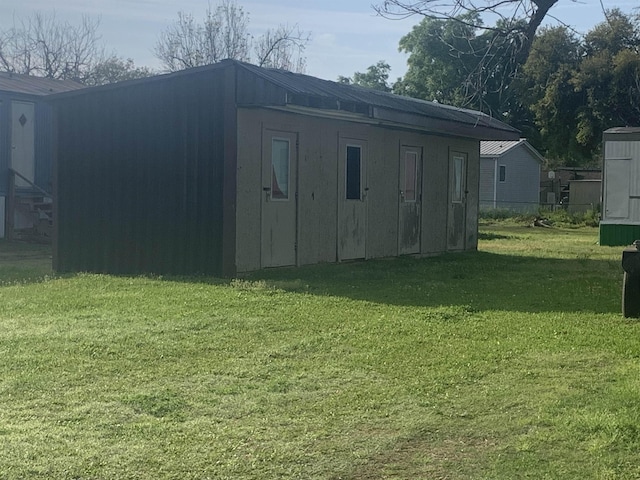 view of outdoor structure featuring a lawn