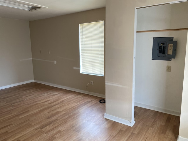 unfurnished room with hardwood / wood-style floors, a wealth of natural light, and electric panel