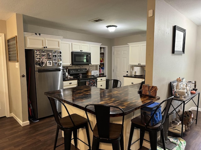 kitchen featuring white cabinetry, dark wood-type flooring, black appliances, and a textured ceiling