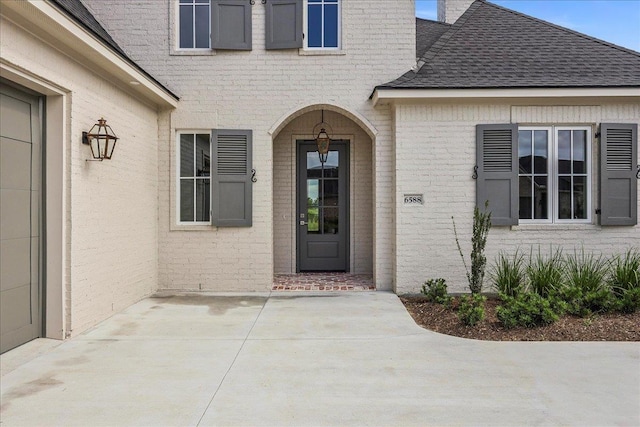 6588 Pointe Park, Beaumont, TX 77706 - entrance to property featuring a shingled roof, brick siding, and a patio