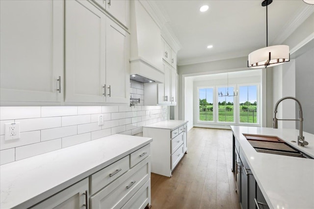6588 Pointe Park, Beaumont, TX 77706 - kitchen featuring a sink, ornamental molding, a chandelier, tasteful backsplash, and pendant lighting