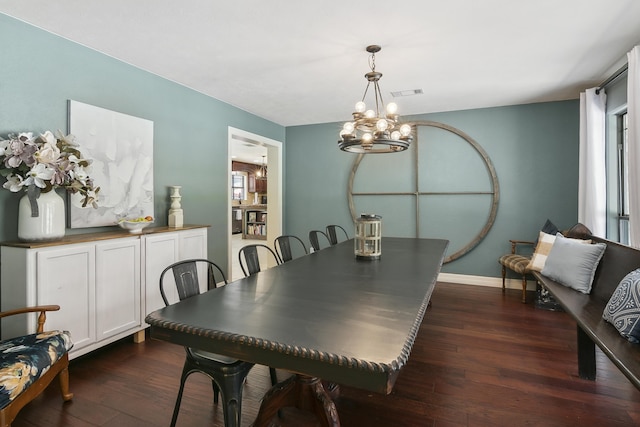 dining area featuring a notable chandelier and dark wood-type flooring