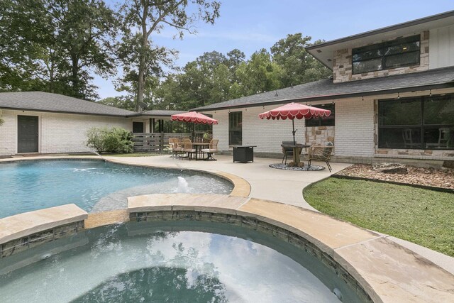 view of pool with an in ground hot tub, pool water feature, and a patio