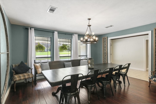 dining space with dark hardwood / wood-style floors and an inviting chandelier