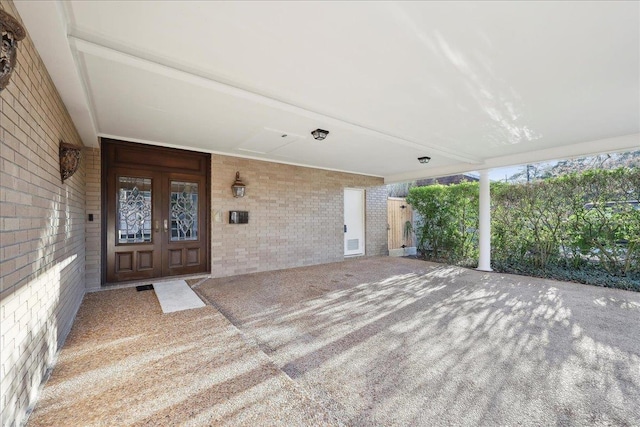 view of exterior entry with french doors and brick siding