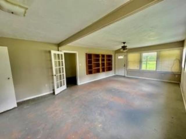 unfurnished living room featuring concrete flooring and beamed ceiling