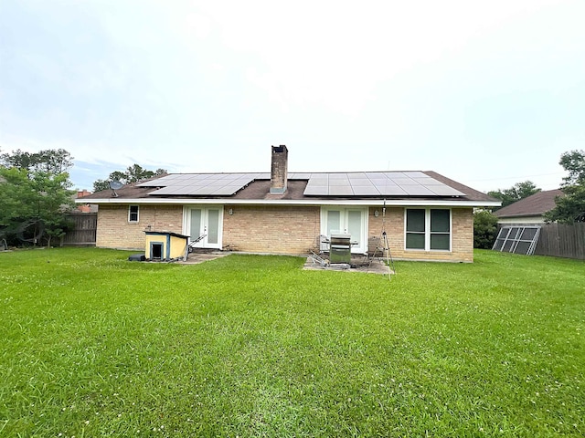 155 Hunters Ct, Lumberton, TX 77657 - rear view of property with french doors, roof mounted solar panels, brick siding, and a chimney
