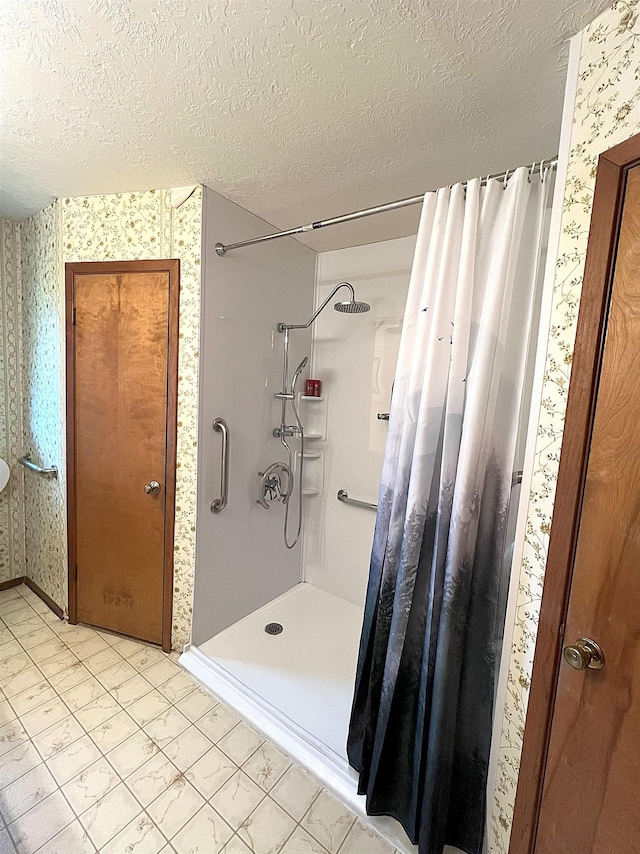 155 Hunters Ct, Lumberton, TX 77657 - bathroom featuring wallpapered walls, a shower stall, a textured ceiling, and baseboards