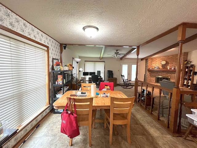 155 Hunters Ct, Lumberton, TX 77657 - dining space with wallpapered walls, ceiling fan, a textured ceiling, baseboards, and a brick fireplace