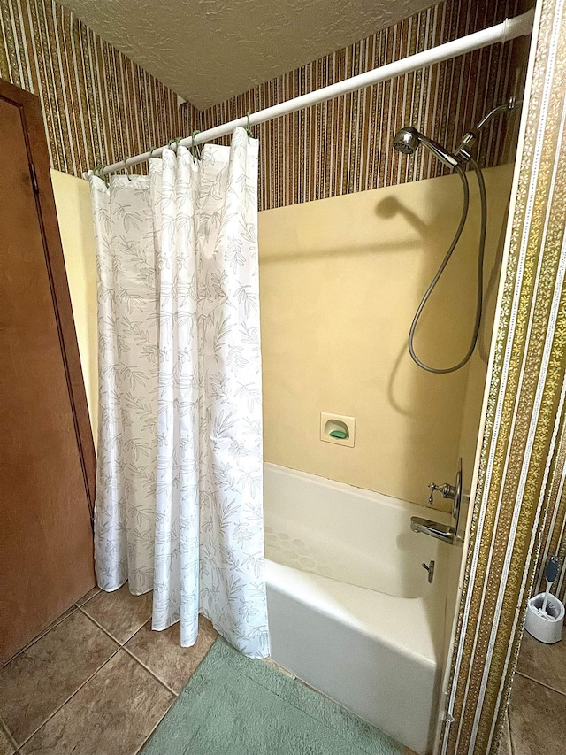 155 Hunters Ct, Lumberton, TX 77657 - bathroom featuring shower / bath combo with shower curtain, tile patterned floors, wallpapered walls, and a textured ceiling