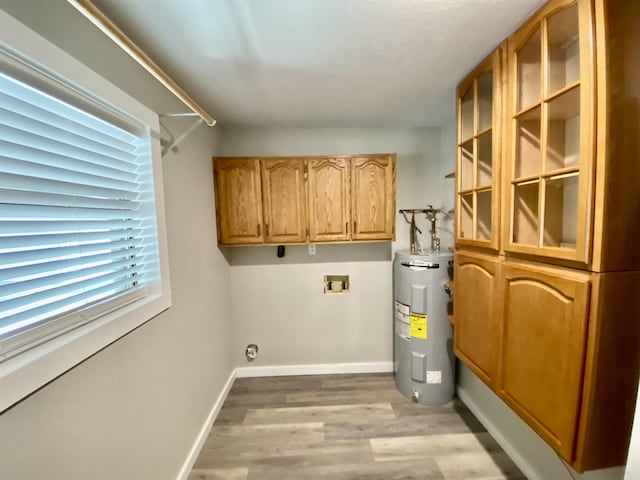 washroom with light wood-style floors, hookup for a washing machine, electric water heater, electric dryer hookup, and cabinet space
