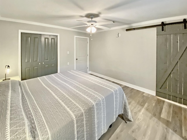 3900 Lakeview Cutoff, Vidor, TX 77662 - bedroom with a barn door, wood finished floors, ceiling fan, ornamental molding, and baseboards