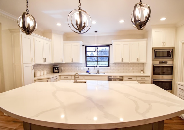 kitchen featuring light stone countertops, a large island with sink, white cabinetry, and stainless steel appliances