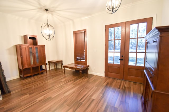 foyer entrance with a chandelier, french doors, hardwood / wood-style flooring, and crown molding