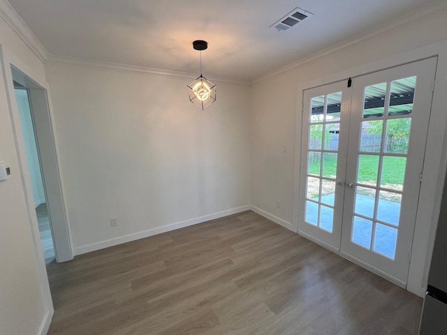 spare room featuring hardwood / wood-style flooring, crown molding, and french doors