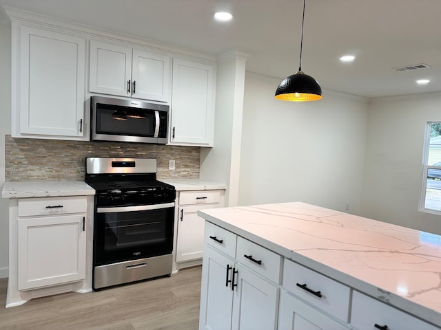 kitchen with white cabinets, pendant lighting, and appliances with stainless steel finishes