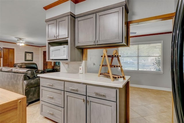 kitchen with ceiling fan, light tile patterned floors, and ornamental molding