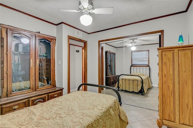 tiled bedroom featuring ceiling fan, a closet, and crown molding