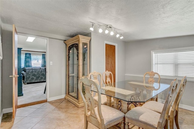 dining area with light tile patterned floors, track lighting, and a wealth of natural light