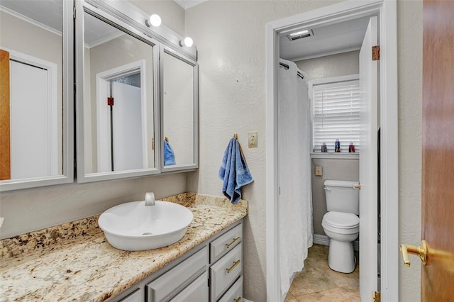 bathroom with vanity, toilet, and ornamental molding