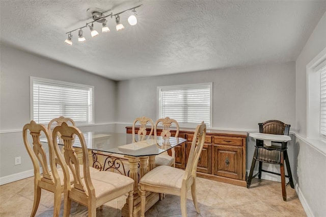 dining room with light tile patterned floors and rail lighting