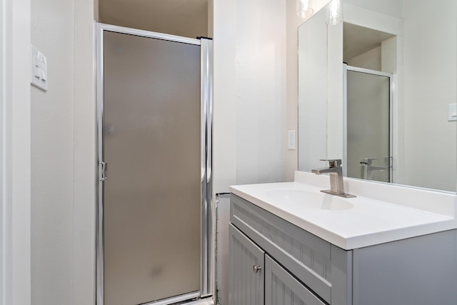 bathroom featuring vanity and a shower with door