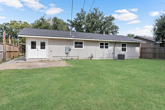 back of property with a lawn and central air condition unit