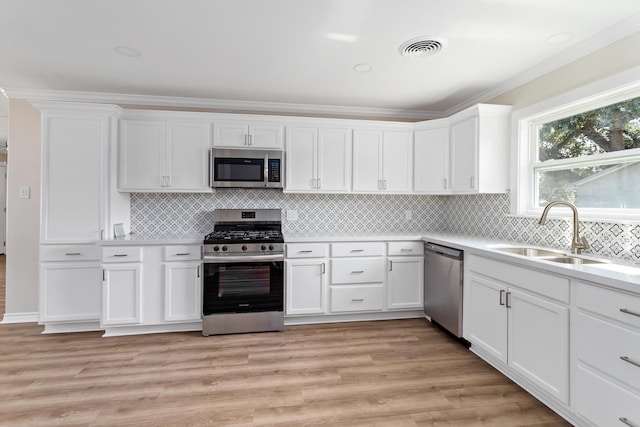 kitchen featuring white cabinetry, sink, light wood-type flooring, and appliances with stainless steel finishes