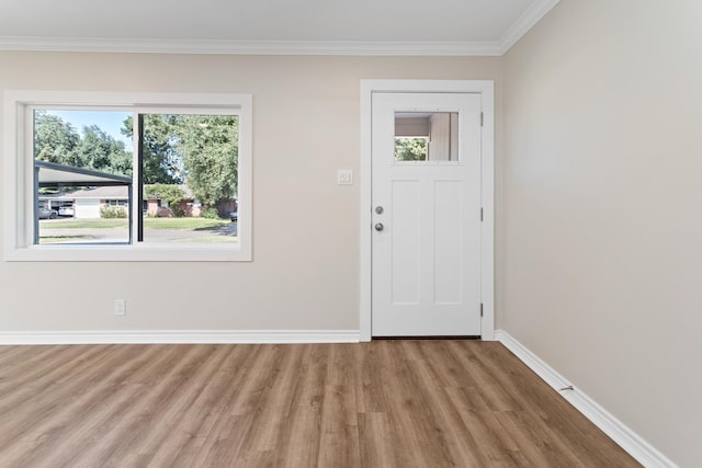 foyer entrance with crown molding, plenty of natural light, and light hardwood / wood-style flooring