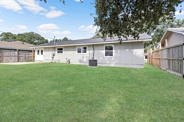 back of property with a lawn and cooling unit