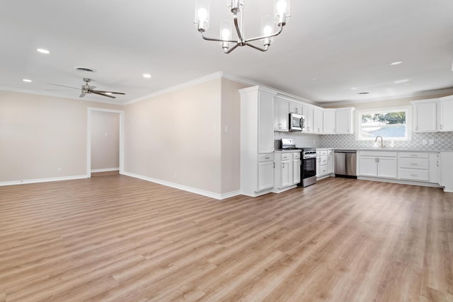 kitchen with hanging light fixtures, appliances with stainless steel finishes, white cabinets, ceiling fan with notable chandelier, and ornamental molding