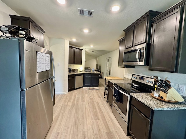 22043 Rocky Reserve Dr, Northwest Harris, TX 77447 - kitchen featuring light wood-type flooring, light stone counters, visible vents, dark brown cabinets, and appliances with stainless steel finishes